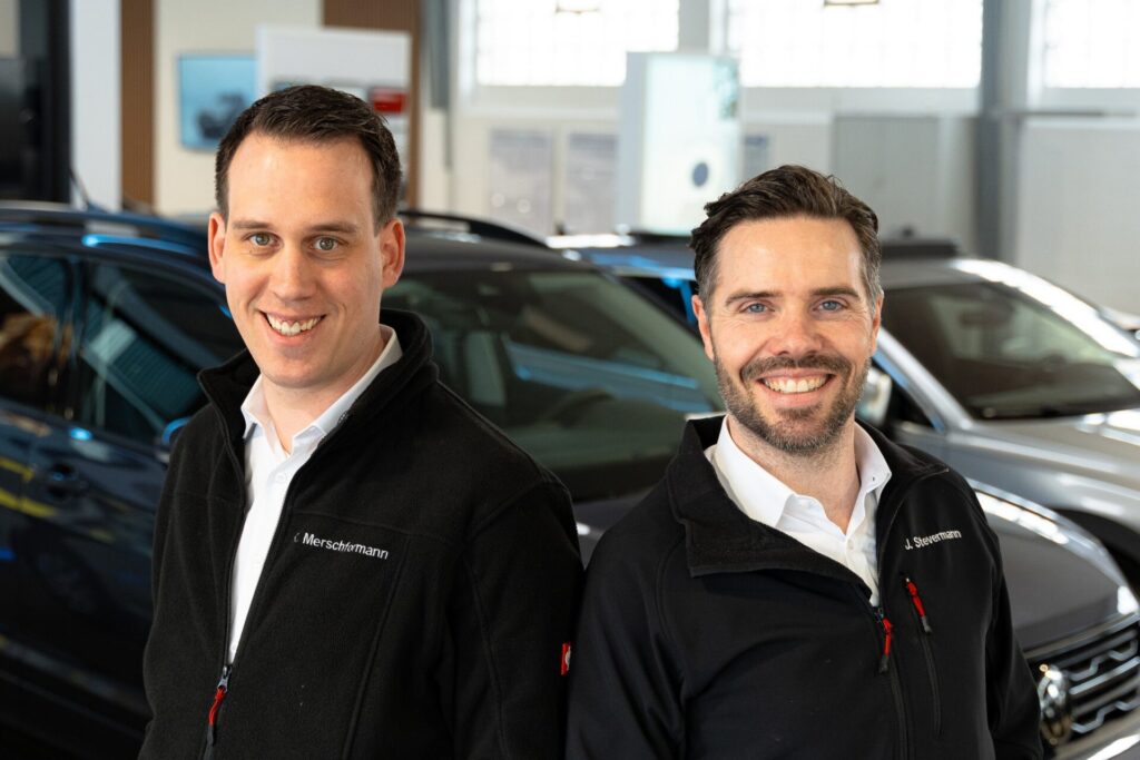 Zwei verkäufer stehen vor einem Auto